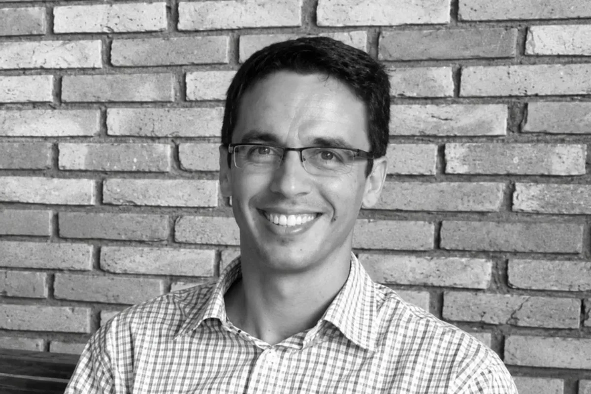 homem de óculos sorrindo