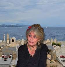 Brigitte Bardot em sua última imagem na TV, em maio de 2025, e o Cemitério de Saint-Tropez ao fundo Foto: Reproduções
