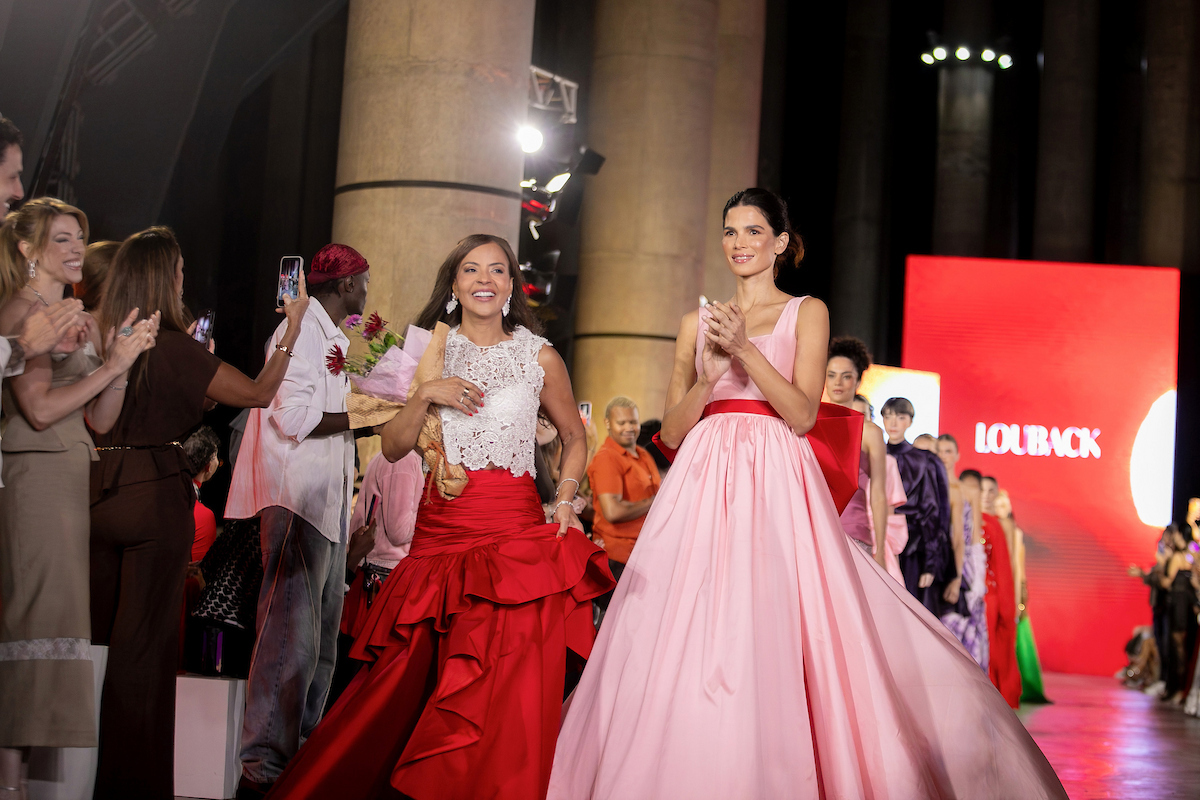 Louback no final do desfile ao lado da modelo Raica Oliveira