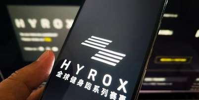Mulher segura um telefone celular mostrando a marca Hyrox Foto: Getty Images / BBC News Brasil