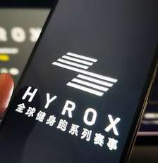 Mulher segura um telefone celular mostrando a marca Hyrox Foto: Getty Images / BBC News Brasil