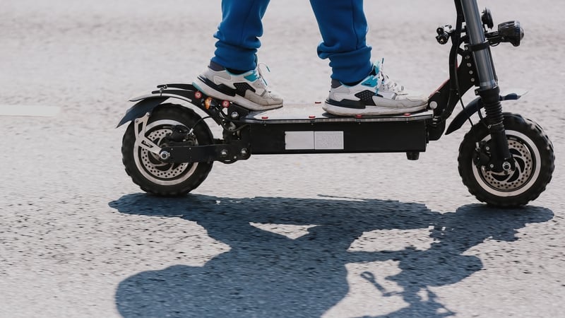 A person rides an e-scooter in the city