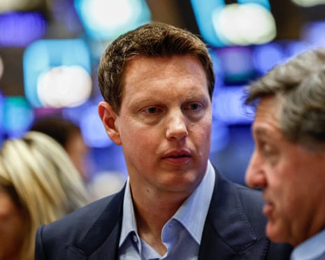 David Ellison talks with colleagues on the New York Stock Exchange trading floor