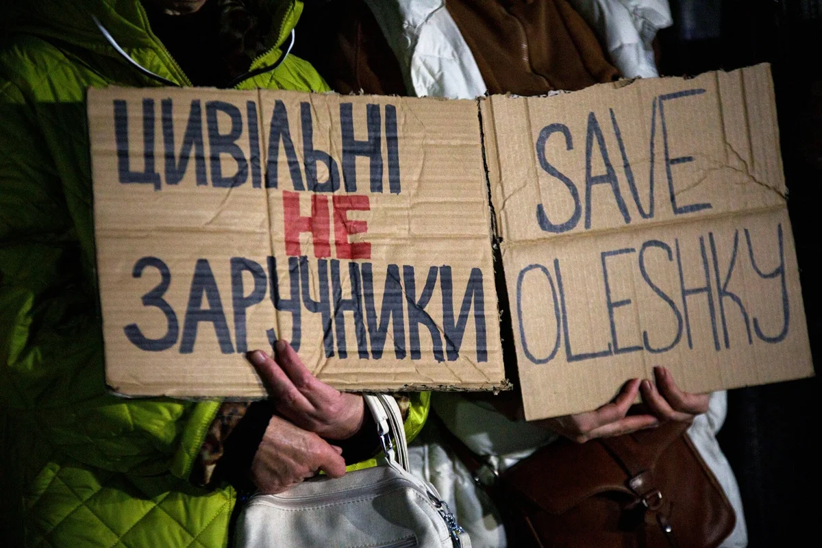 Ativistas seguram cartazes com palavras de ordem durante uma manifestação em apoio aos moradores de Oleshky, na região de Kherson, pedindo à comunidade internacional que volte sua atenção para a situação humanitária na cidade — que se encontra sob ocupação russa