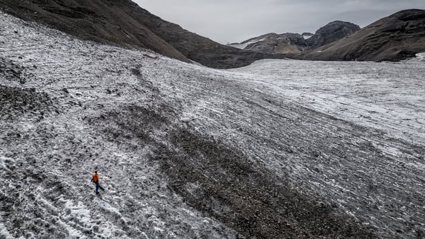 Matthias Huss, head of the "Glacier Monitoring in Switzerland" (GLAMOS) network, walking towards a measuring stake during a visit to record changes in the melting Scex Rouge glacier